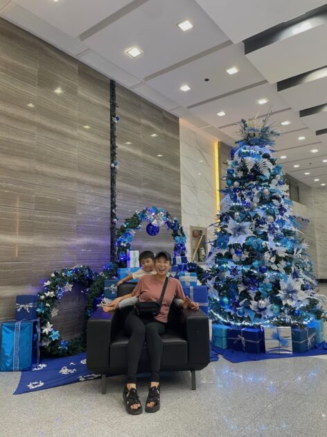 ブ島のコンドミニアムのロビーのクリスマスツリー前で撮影した、とびきり笑顔の親子ツーショット写真